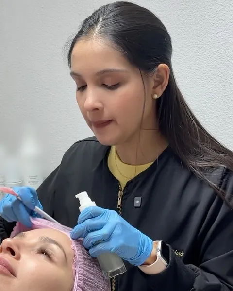 La Dra. Génesis Calderón durante un procedimiento facial en su consulta